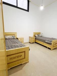 two beds are in a room withthritisthritisthritisthritisthritisthritisthritisthritisthritis at Spacious apartment for a comfortable stay in Al Hoceïma