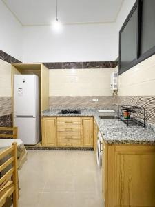 a kitchen with wooden cabinets and a white refrigerator at Spacious apartment for a comfortable stay in Al Hoceïma