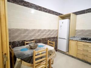 a small kitchen with a table and a refrigerator at Spacious apartment for a comfortable stay in Al Hoceïma +5 photos