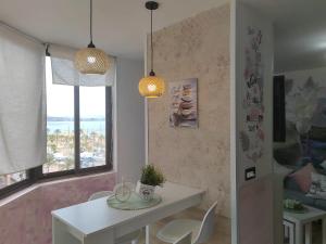 a dining room with a white table and two lights at Bright apartment with sea view, Fuengirola, 50 m², pool in Fuengirola