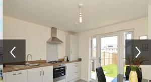 a kitchen with white cabinets and a stove top oven at Edinburgh upper villa end terrace in Edinburgh