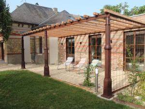 a wooden pergola with chairs in a yard at Gîte de charme avec spa, piscine intérieure et jardin clos près de Chinon - FR-1-381-553 in Beaumont-en-Véron
