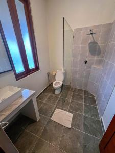 a bathroom with a shower and a toilet and a sink at Ecosfera Hotel & Spa in Canggu
