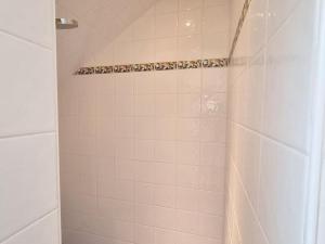 a bathroom with a shower with white tile at Appartement mansardé rénové à Rambouillet, 2 chambres, tout inclus, proche château et gare. - FR-1-527-47 in Rambouillet