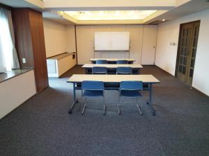 a classroom with tables and chairs and a whiteboard at Hotel Route-Inn Court Chikuma-Koshoku in Chikuma