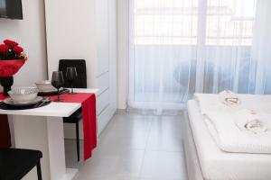 a white room with a table and a couch and a window at Silver Moon Residence 1 in Arad