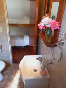 a bathroom with a sink and a vase of flowers at Casa El Tabaquillo in Nono +13 photos