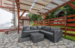 a patio with a couch and a bench under a pergola at Awesome Home In Novo Zvecevo With Sauna in Novo Zvecevo