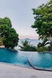 a swimming pool with a view of the ocean at Eliana Resort And Spa in Nembrala