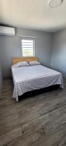 a bedroom with a bed with a wooden floor at A modern and cozy 2 bedroom apartment in Willemstad
