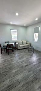 a living room with a couch and a table and chairs at A modern and cozy 2 bedroom apartment in Willemstad