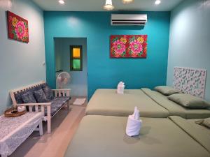 a room with two beds and a couch at Baanrak amphawa homestay in Amphawa