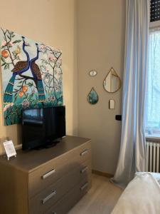 a bedroom with a dresser with a television on it at Apartments via Roma in Rovereto