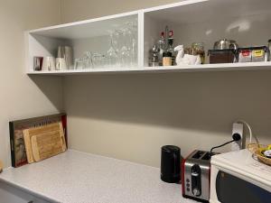 a kitchen with white shelves and a counter top at The Red Letterbox in Blackheath +13 photos