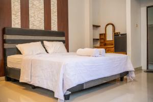 una camera da letto con un letto con due asciugamani sopra di Twin OLA a Tabanan