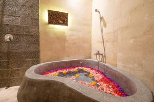 a bath tub filled with flowers in a bathroom at Villa Unique in Ubud