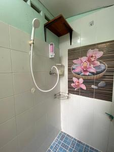 a bathroom with a shower with a painting of flowers on the wall at Green Garden Hostel in Bangkok