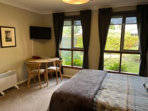 a bedroom with a bed and a table with chairs at The Red Letterbox in Blackheath
