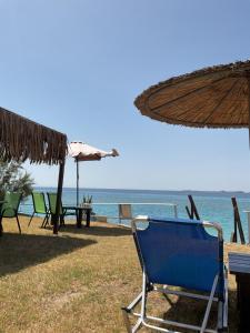 a blue chair and an umbrella on the beach at Kefalonia Beach Hotel & Bungalows in Lixouri