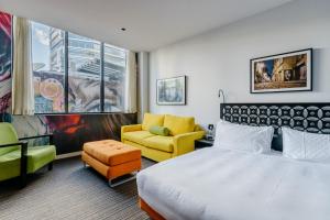 una camera d'albergo con un letto e delle sedie di The Constance Fortitude Valley a Brisbane