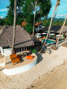 une plage avec un banc et un complexe hôtelier avec un bateau dans l'établissement Wild Wood x Hansa Beach Fitness Resort, à Thongsala 55 autres photos