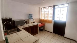 a kitchen with a black door and a television at Acogedora Casa Completa con jacuzzi privado in Quito