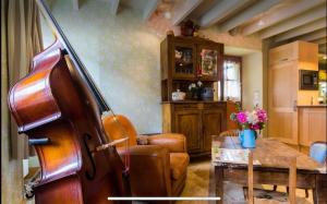 a living room with a violin and a table at La petite maison dans la campagne in Massingy-lès-Vitteaux +8 photos