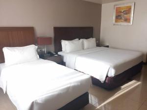 Postel nebo postele na pokoji v ubytování Mandarin Plaza Hotel