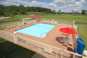 an overhead view of a swimming pool with a red umbrella at Country Inn & Suites by Radisson, Sandusky South, OH in Milan