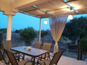 a patio with a table and chairs and an umbrella at Αρχοντικο in Ayía Sofía