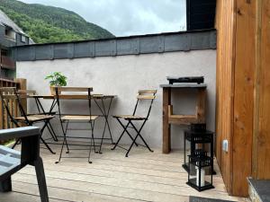 a patio with chairs and tables on a balcony at REFUGE DU CAP in Saint-Lary-Soulan
