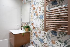 a bathroom with a toilet and a floral wallpaper at Rhoome Holiday 1 in Rome +44 photos