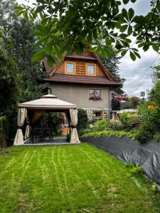 una casa con una mesa y una sombrilla en el patio en U Lassaków, en Poronin