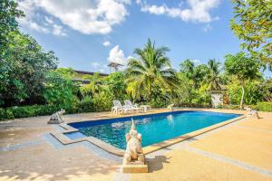 a swimming pool with a statue in front of a house at Samran Resort in Chalong