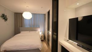 a bedroom with a bed and a flat screen tv at WECO STAY Myeongdong in Seoul