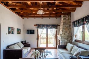 a living room with two couches and a stone fireplace at House Demetra in Astris