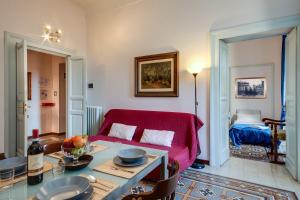 Una sala de estar con un sofá rojo y una mesa. en Otium Maecenatis Apartments, en Roma