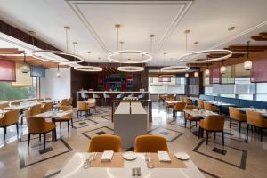 a rendering of a restaurant with tables and chairs at Ramada Encore by Wyndham Udaipur Roopnagar in Udaipur