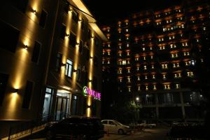 a building with a neon sign in front of it at Parklane Hotel in Tashkent