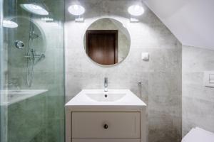 a bathroom with a sink and a shower and a mirror at Pokoje blisko morza Przy Porcie in Darłowo +63 photos