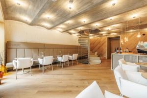 a dining room with white chairs and a bar at SKLEP 38 in Velké Bílovice