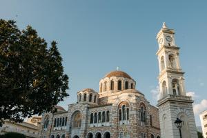 a building with a clock tower on top of it at DEMs central stay Volos with private parking in Volos