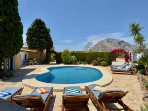 a swimming pool with chaise lounges and lawn chairs at Secrets Rural House in Jávea