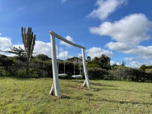a swing set in a field with a palm tree at Camping Near Mt Longonot, Elwai Camping Centre in Heni Village