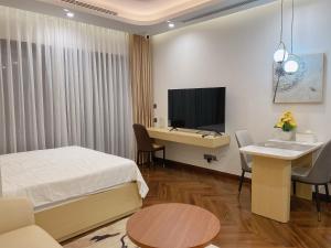 a bedroom with a bed and a desk and a television at Cozy studio Apartment in Diamond Crown Hai Phong 1218A in Hai Phong
