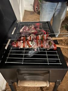 a grill with meat and vegetables on it at BH villa in Houmt Souk