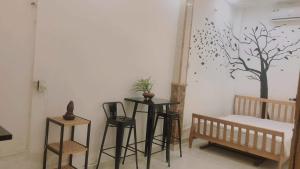 ein Raum mit zwei Tischen und Stühlen und einem Baum an der Wand in der Unterkunft Alleyway home in Ho-Chi-Minh-Stadt + 30 Fotos