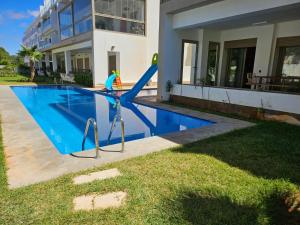 a swimming pool with a slide in front of a house at Hiba's studio in Mohammedia
