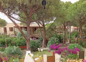 a garden with trees and flowers in front of a building at Casa Vacanze Eloise in Quartu SantʼElena