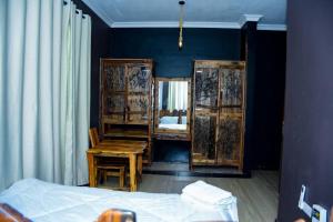 a bedroom with a bed and a desk and a mirror at Love House in Dodoma
